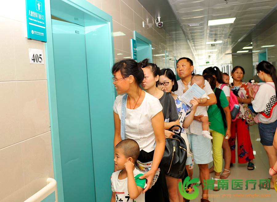 参加讲座的家长们在护士台给孩子领取义诊体检表后在相应科室门前排队候诊。记者 王梦 摄