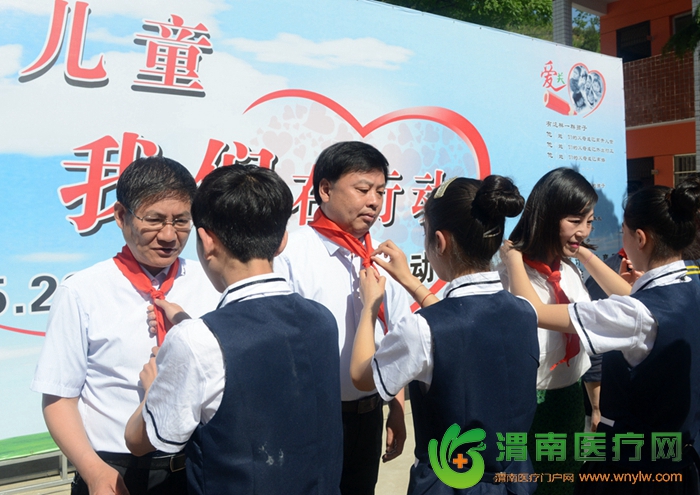   孩子们为了感谢大家的关心与付出，学校的少先队员们为参加活动的领导、嘉宾“一对一”佩戴红领巾。记者 杨大君 摄