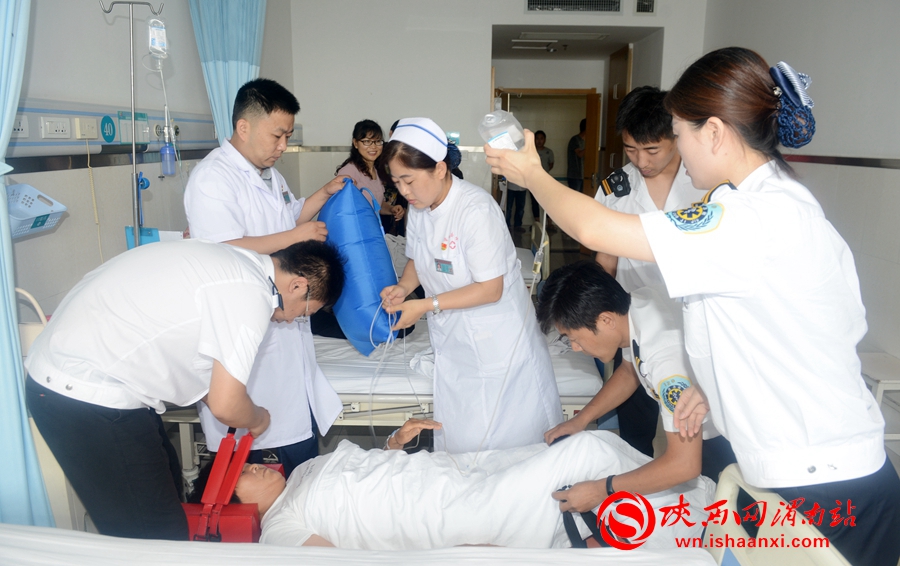 医护人员将危重病人抬上担架车。记者 杨大君 摄
