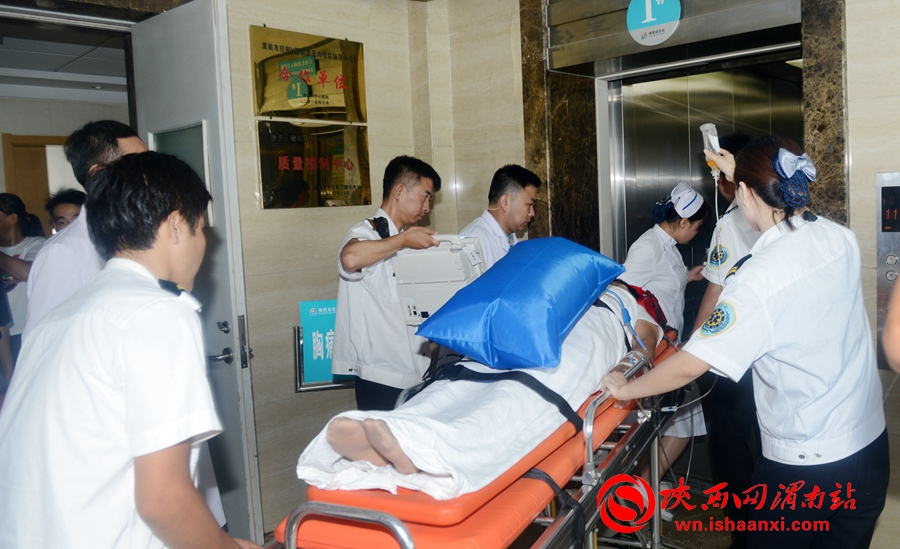 医护人员将危重病人送至电梯。记者 杨大君 摄