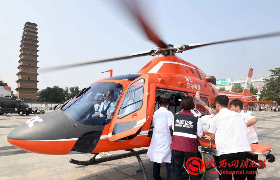 医护人员将病人抬上救援直升机。记者 杨大君 摄